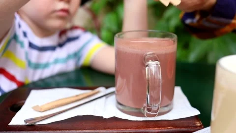 Little happy smart boy drinking cacao beverage outside. Children health care 스톡 동영상 161117348