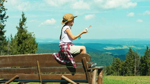 Little hiker girl 7-8 years old playing with soap bubbles Stock Footage