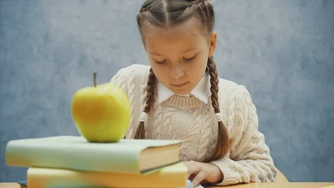 Little hungry pupil stops a learning process to smell an apple. Stock Footage 113072331