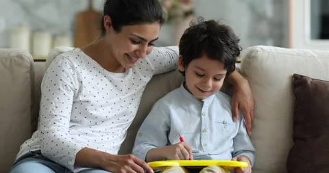 Little Indian boy and mother drawing on magnetic erasable board Stock Footage