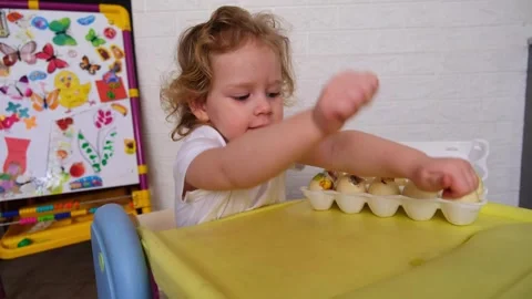 Little kid decorating easter egg during christian holiday celebration. Small boy Stock Footage 330108959