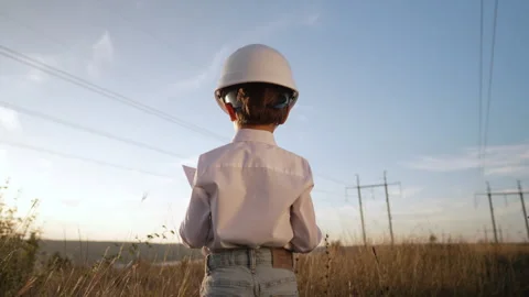 Little kid as engineer or manager with safety helmet, investigates electrical Stock Footage 288709264