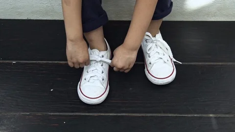 The little kid learning use hand to tie a shoes Video stock 104400609