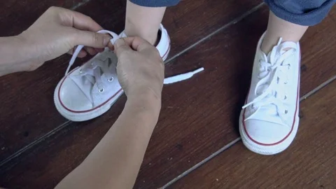 The little kid learning use hand to tie a shoes, Teaching Your Child for Pare Video stock 104686387