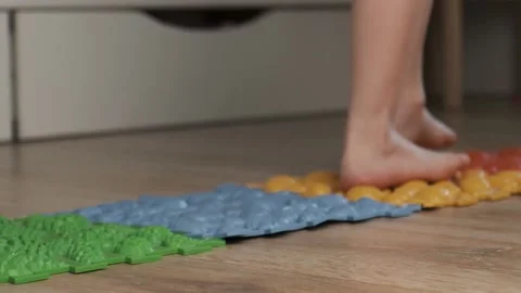 Little kid making exercises on the rubber orthopedic puzzle mat Video stock 237332150