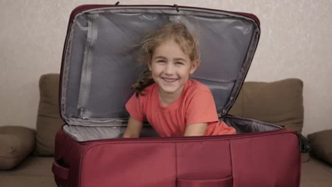 Little Kid Is Playing Inside Suitcase. Little Kid in Travel Buggage. Packed f Stock Footage 169337792