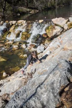 Little kid playing next to a river in Palencia, Spain, during the winter endi Stock Photos