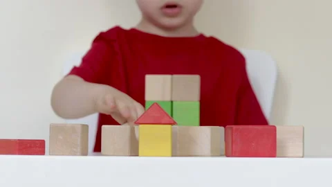 Little kid playing at table with eco wooden colorful cubes Stock-Footage 199574788