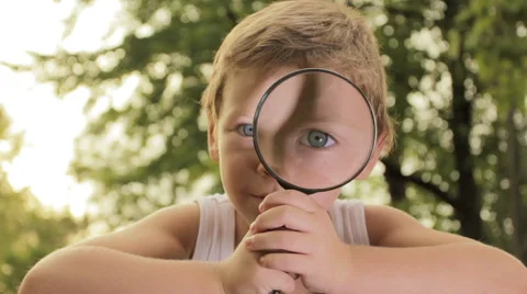 Little kid searching, exploring with magnifier Stock Footage