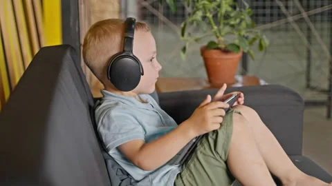 Little kid with tablet pc dancing to music he listening in headphones Stock Footage 232256562