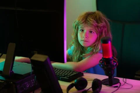 Little kid using desktop pc by night, child boy illuminated by the blue light of Stock-Fotos