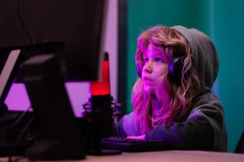 Little kid using desktop pc by night, child boy illuminated by the blue light of Stock-Fotos