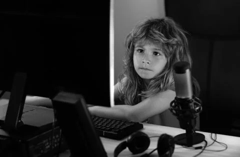 Little kid using desktop pc by night, child boy illuminated by the blue light of Stock-Fotos