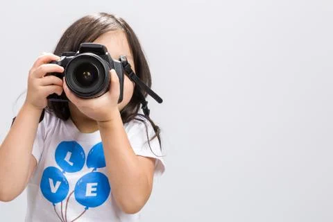 Little kid using DSLR camera to take some photos in studio. Foto stock