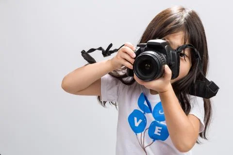 Little kid using DSLR camera to take some photos in studio. Stock Photos