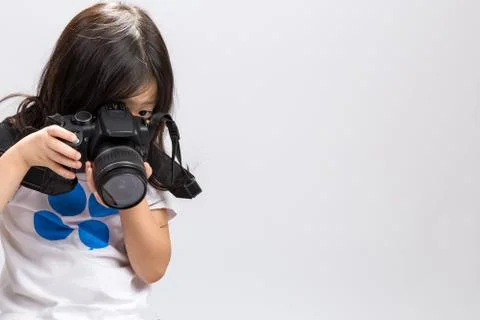 Little kid using DSLR camera to take some photos in studio. Stock Photos