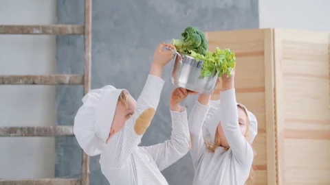 Little kids are playing chiefs with garden vegetables. Stock Footage