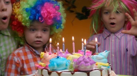 Little kids blows out candles on birthday cake at party, slow motion Stock Footage