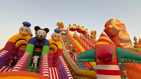 Little kids playing in Mickey Mouse Kids Jumper, Sliding Bouncer Stock Footage 249815564