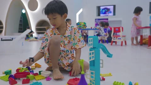 Little kindergarten boy enjoy playing coloyful toy block in school Stock Footage 268676953