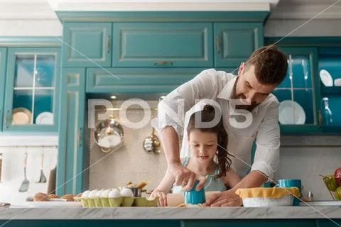 Little lady making cookies with daddy in kitchen Stock Photos