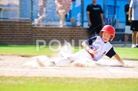 Little league baseball player sliding home. Stock Photos