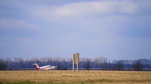 Little light aircraft is taking off from the empty aerodrome.  Video stock 256185605