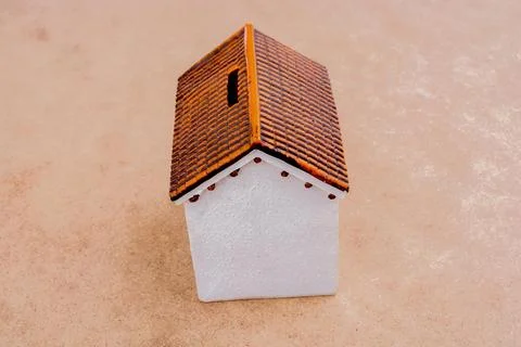 Little model house placed on a brown background 写真素材