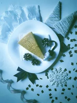 Little mouse eats cheese from a plate on New year's Eve Stock Photos