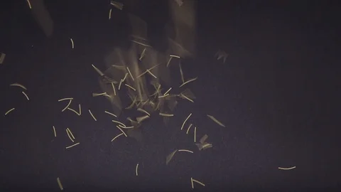 Little noodles fall on a black table. Pasta rolls on a black table Stock Footage 120451636