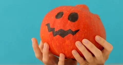 Little orange pumpkin thinks on blue background Stock Footage 117416403