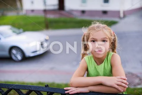 Little Pensive Girl On Background Of Passing Car