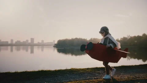 Little pilot boy running in fun airplane costume with glasses at epic sunset Stock Footage 99772818