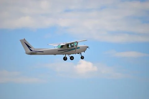 Little plain flying in a cloudy sky Stock Photos