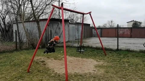 Little Polish kid swinging on the swing in the playground in Swiecie, Poland Stock Footage 238024924