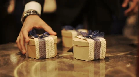 Little present boxes decorated with blue ribbons stand on the wooden table Stock Footage 68995847