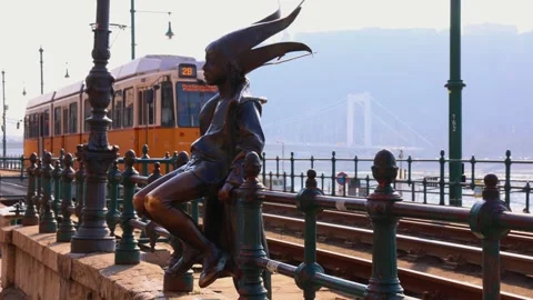 Little princess statue observing passing tram in Budapest Stock Footage 303102114