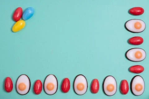 Little red Easter eggs arranged alternately with Easter candies designed as e Stock Photos