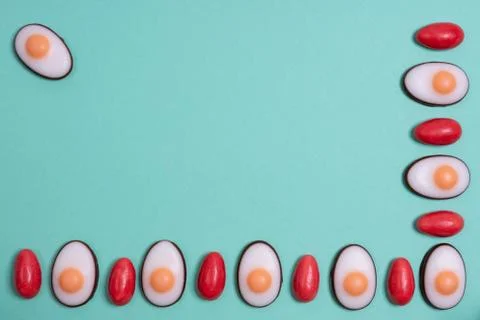 Little red Easter eggs arranged alternately with Easter candies designed as e Stock Photos