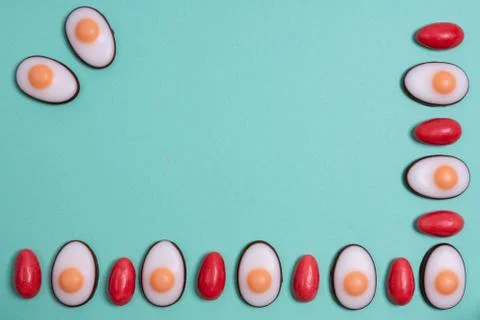 Little red Easter eggs arranged alternately with Easter candies designed as e Stock Photos