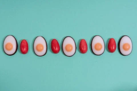 Little red Easter eggs arranged alternately with Easter candies designed as e Stock Photos
