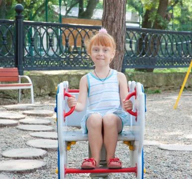 Little red-haired girl at the various attractions Stock Photos