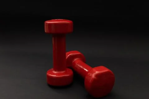 Little red weights on a black background Stock Photos