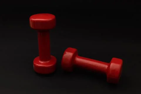 Little red weights on a black background Stock Photos