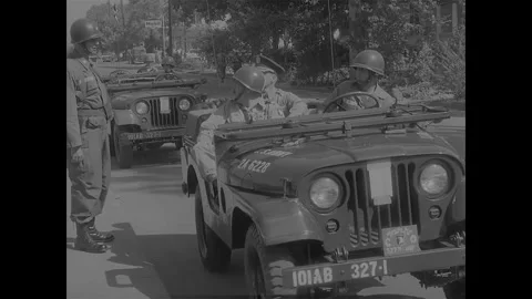 LITTLE ROCK - 1957: Desegregation — Open jeeps carry soldiers on suburban road Stock Footage 342230940