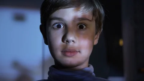 Little Scared Boy watching Horror Film or Video on TV or Computer in the Dark Stock Footage 97255488