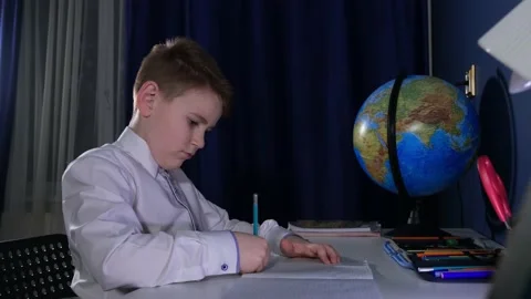 Little schoolboy draws in a notebook 库存影片 169307289