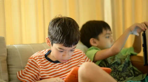 Little sibling boy playing game tablet mobile together Stockbeeldmateriaal 65035353