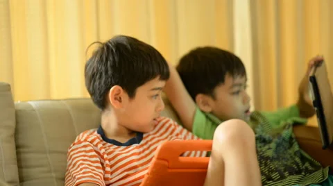 Little sibling boy playing game tablet mobile together Stockbeeldmateriaal 65820512