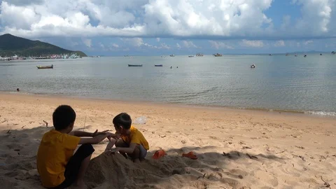 Little sibling boy playing sand on the beach summer time Stock-Footage 89755541